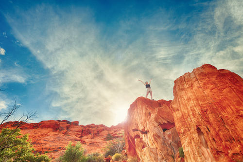 Woman Standing On Red Rocks Celebrating Success-2